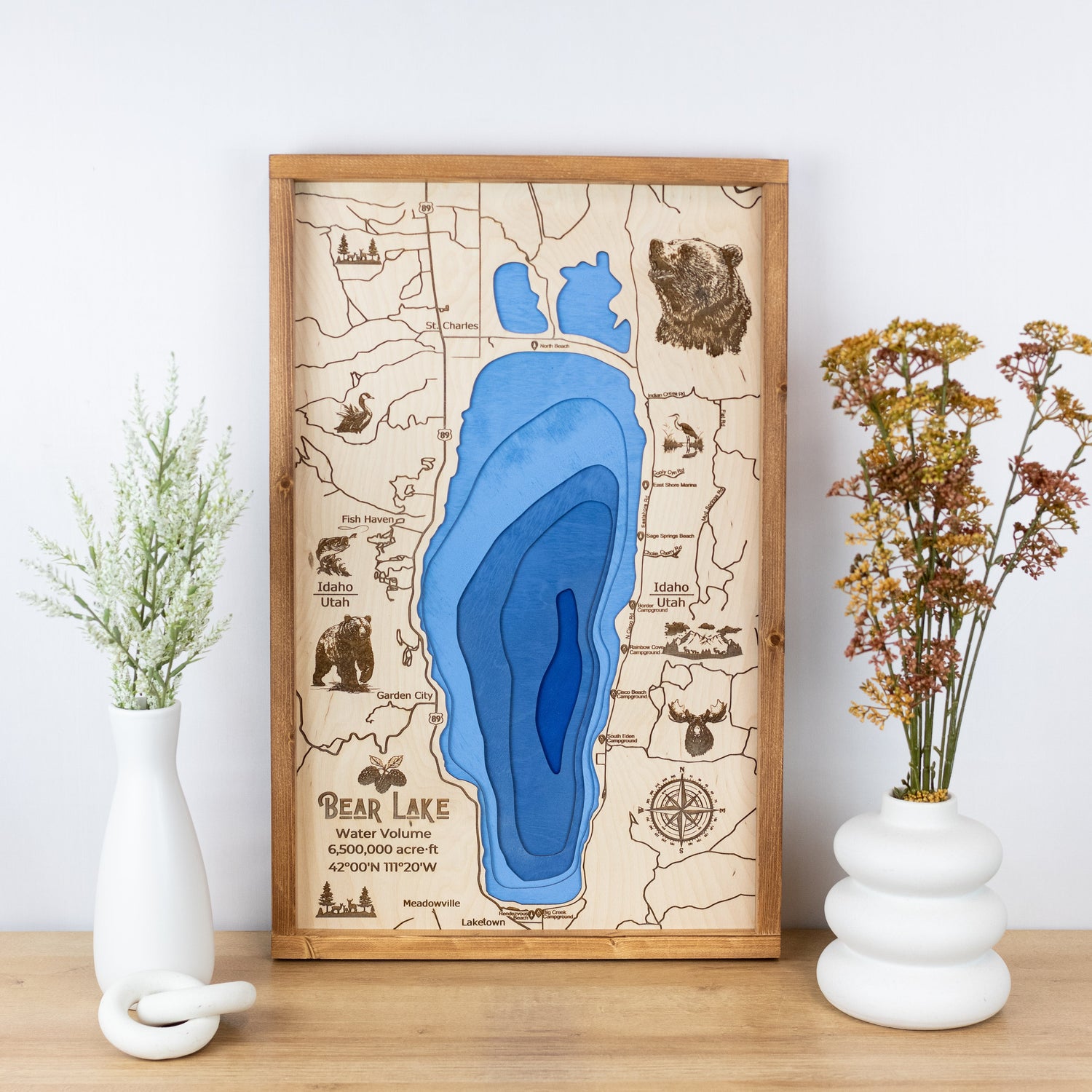 Wooden map of Bear Lake with layered blue water and engraved details, displayed on a shelf.